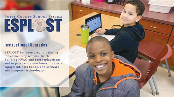 students at computers smiling at the camera 